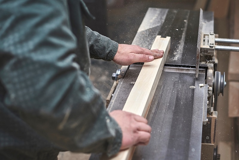 Man processes piece of wood on the jointer