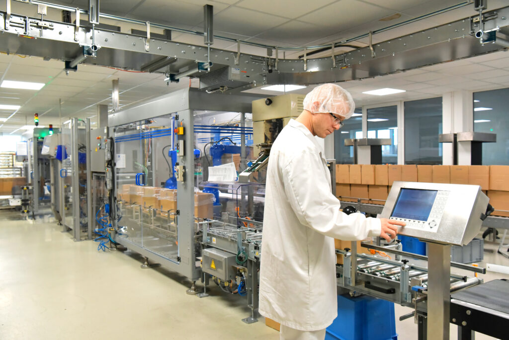 medical products manufacturing in a modern factory - worker operates modern industrial plant