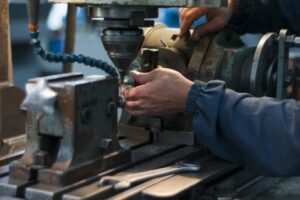 Close up of a machinist's hands working on a piece of equipment